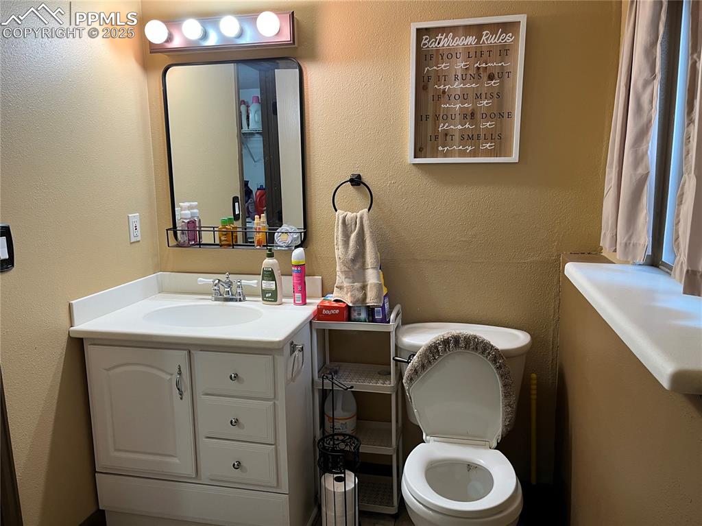 Image 15 of 17: Half bathroom featuring a textured wall and vanity
