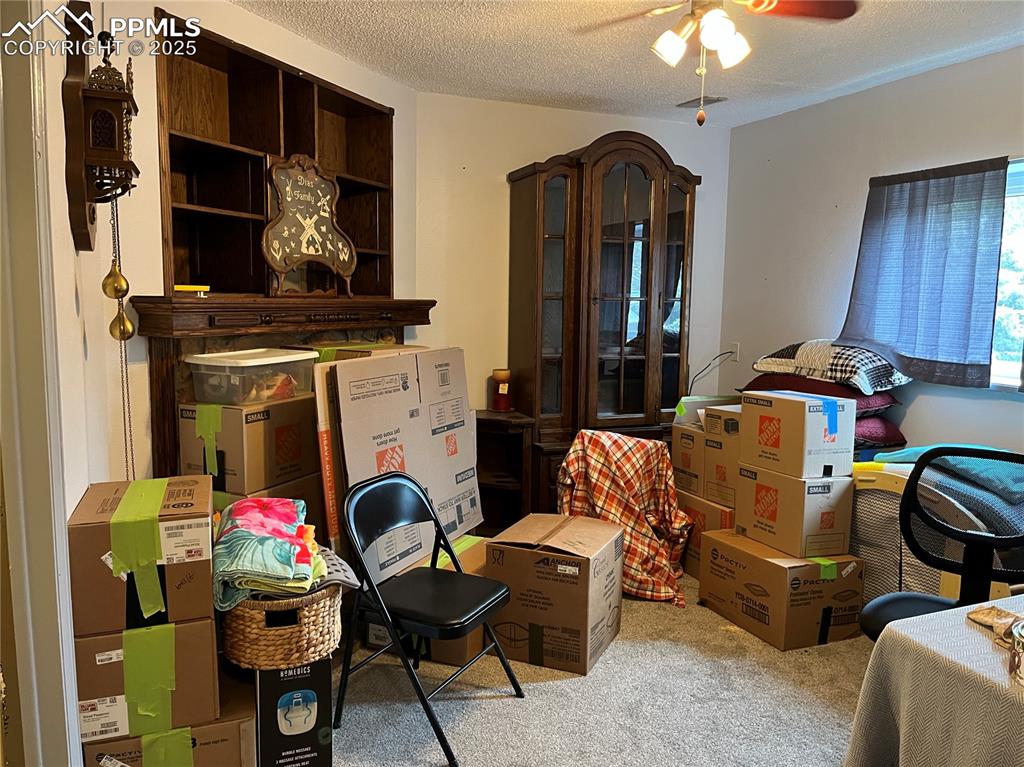 Image 16 of 17: Office with carpet, ceiling fan, and a textured ceiling