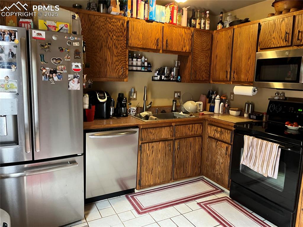 Image 17 of 17: Kitchen featuring stainless steel appliances, light tile patterned floors, 