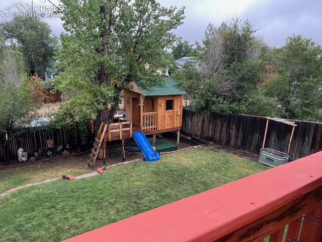 Image 4 of 17: View of jungle gym with a fenced backyard and a wooden deck