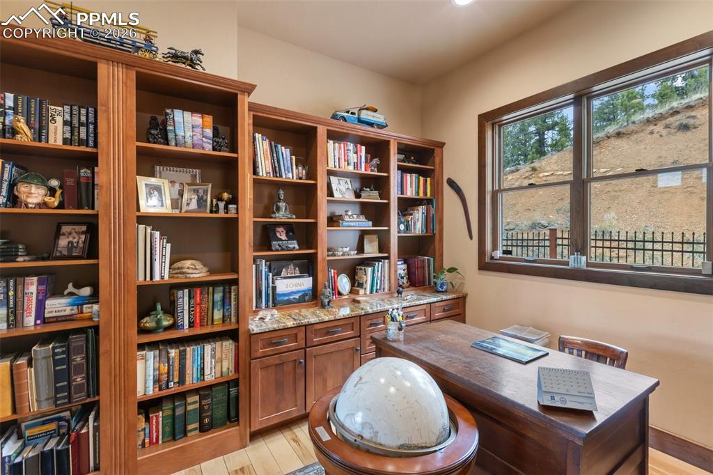 Image 22 of 47: Office with built ins and book shelves, french doors.
