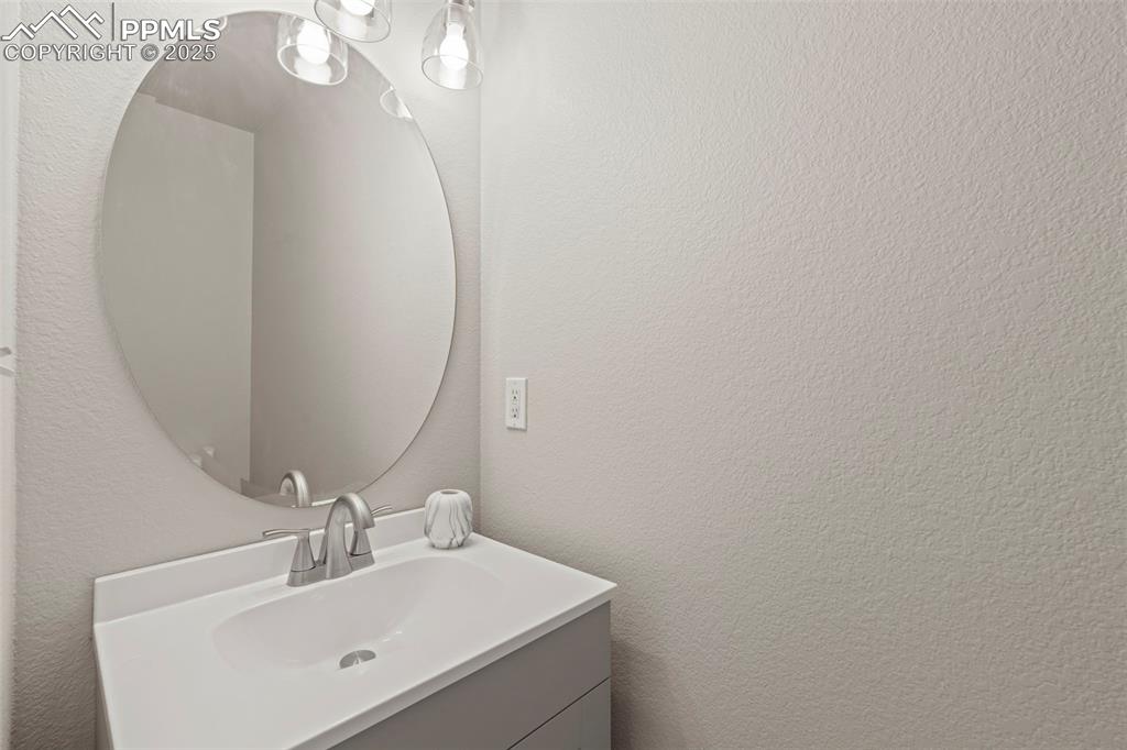 Image 18 of 42: Main floor guest bathroom featuring a textured wall and vanity (pocket door