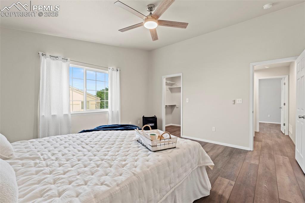 Image 21 of 42: Bedroom featuring LVP floors, a spacious closet, and a ceiling fan