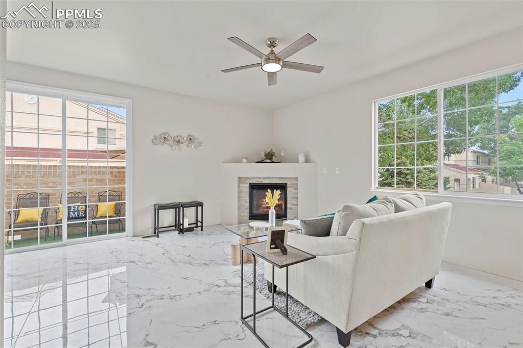 Image 3 of 42: Living area featuring porcelain tile with marble design flooring, a warm l