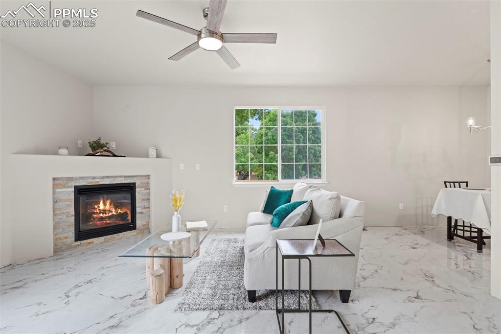 Image 7 of 42: Living room with porcelain tile with marble design flooring and a fireplac