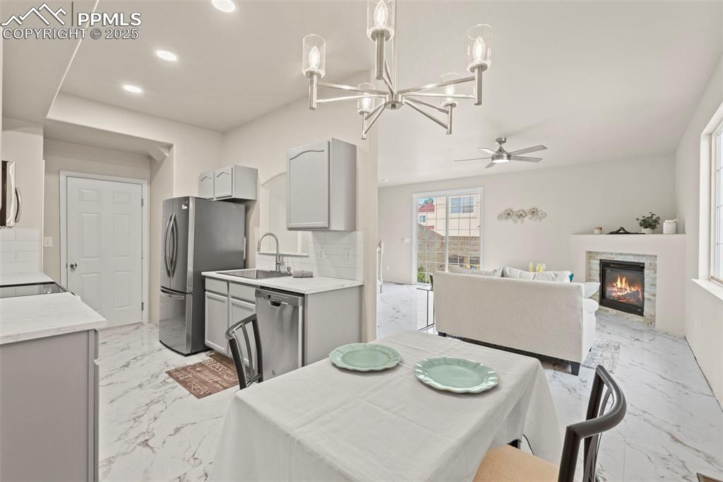 Image 8 of 42: Kitchen featuring light porcelain tile with marble design flooring, decora