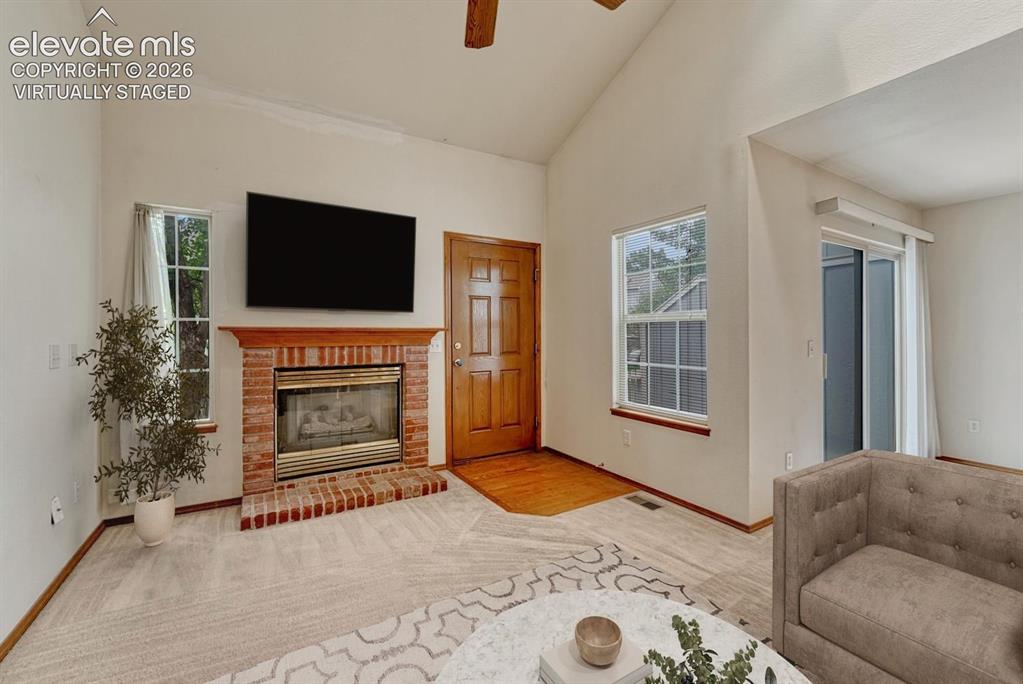 Image 18 of 50: Brick fireplace accents the living room. Virtually staged.