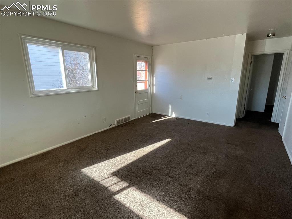 Image 9 of 15: Living room with pic of side door entrance.