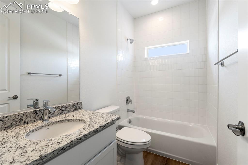 Image 29 of 34: Bathroom with shower combination, vanity, and dark wood-type flooring