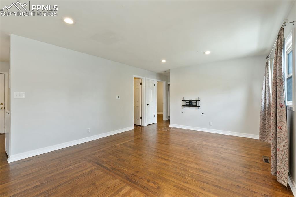 Image 12 of 36: Spare room featuring dark wood-style floors and recessed lighting