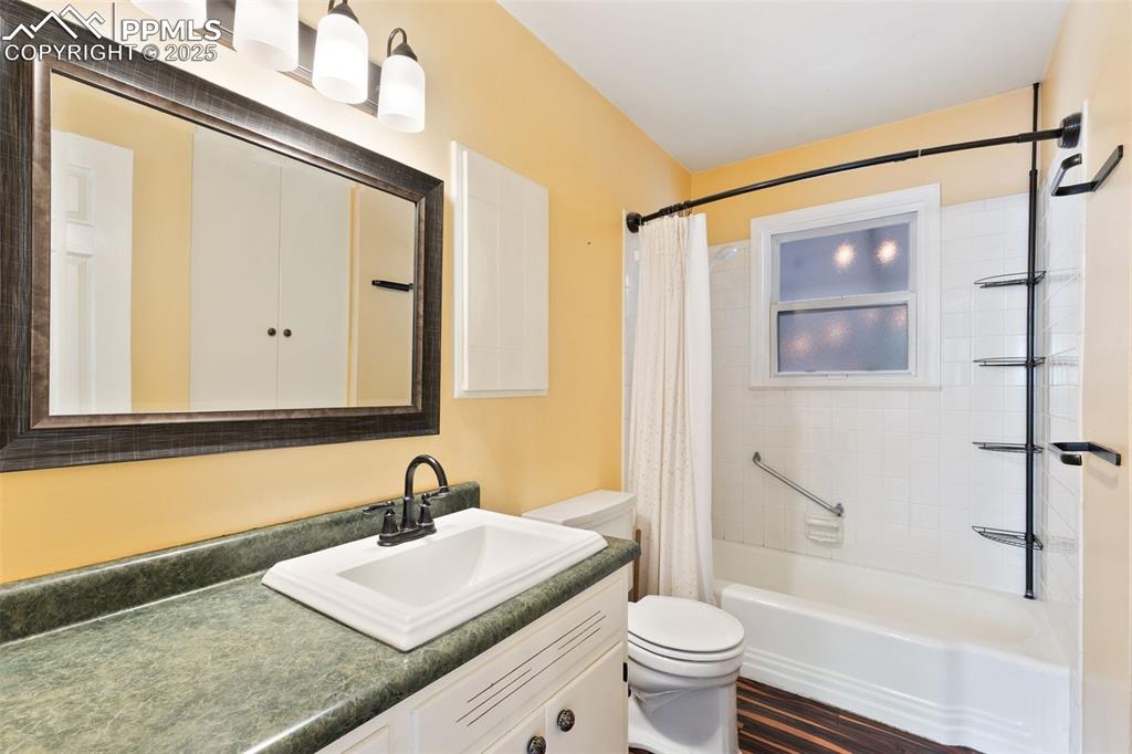Image 21 of 36: Full bath with vanity, shower / bath combination with curtain, and wood fin