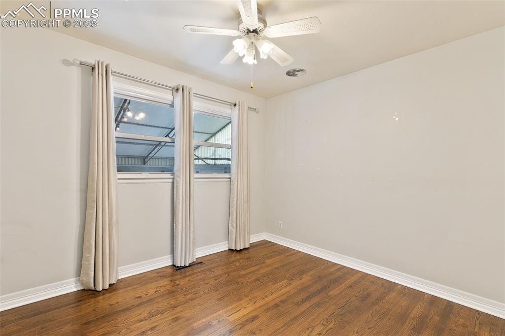 Image 22 of 36: Unfurnished room featuring dark wood-style flooring and a ceiling fan