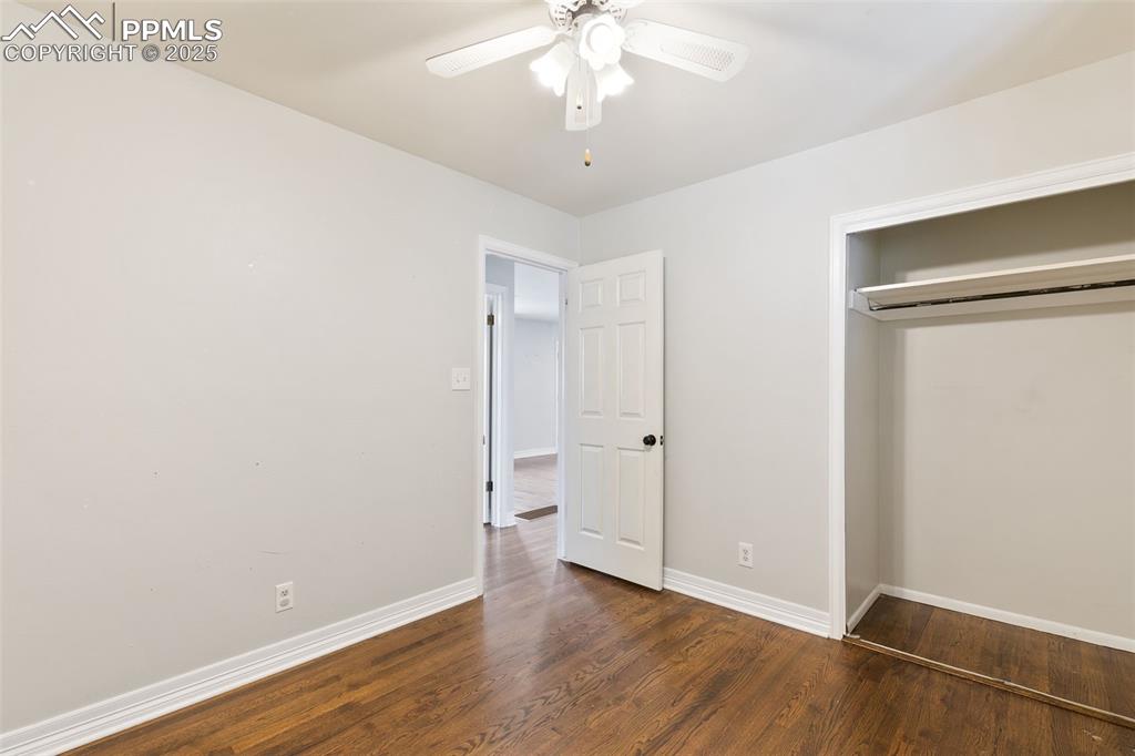 Image 24 of 36: Unfurnished bedroom with wood finished floors, a closet, and a ceiling fan