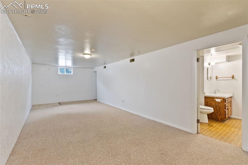 Image 27 of 36: Basement with carpet floors and baseboards