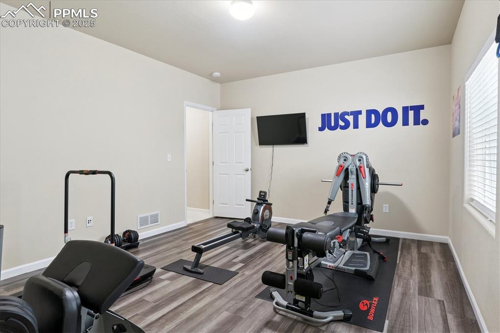 Image 19 of 29: Exercise area featuring wood finished floors