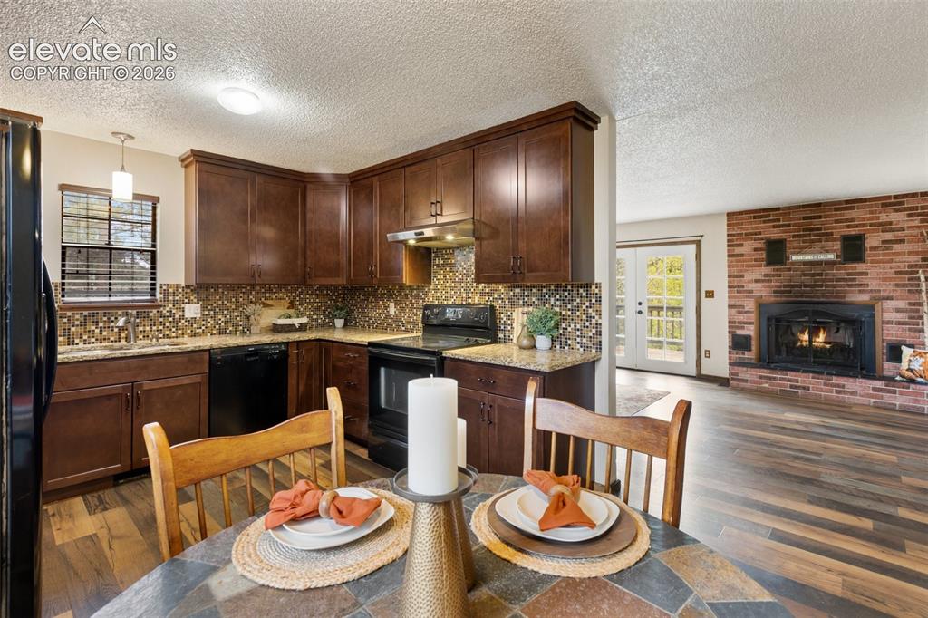 Image 10 of 41: Functional kitchen featuring wood cabinetry, mosaic tile backsplash, and da
