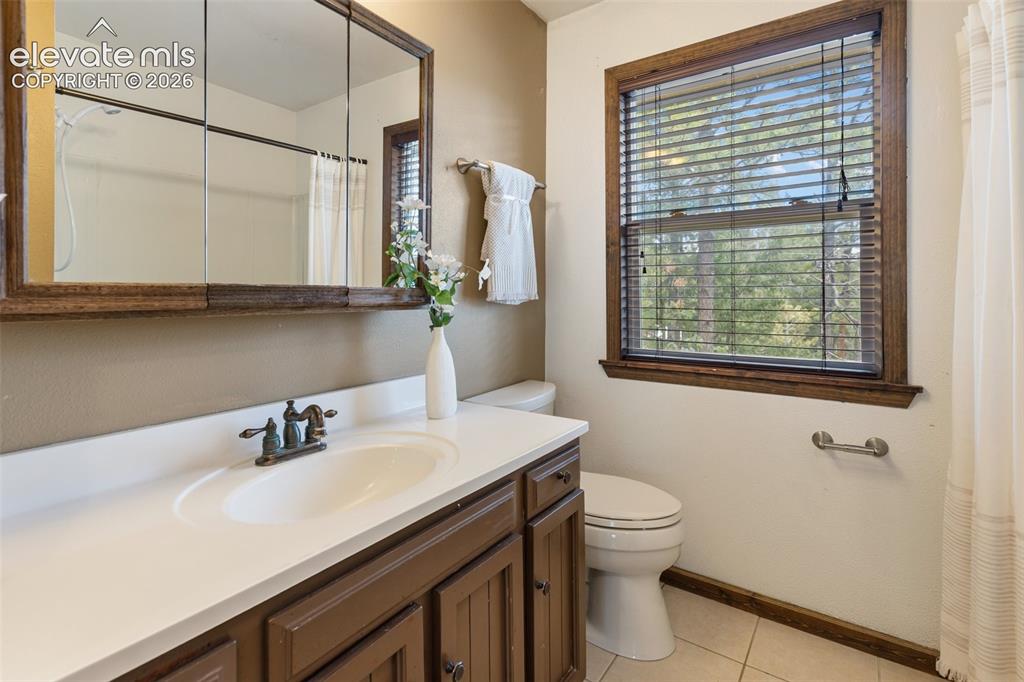 Image 16 of 41: Bathroom vanity featuring a white oval sink, bronze-finish faucet, and buil