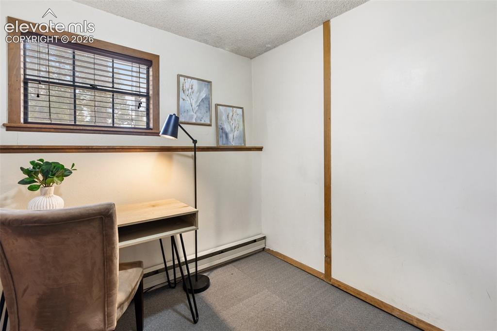 Image 25 of 41: Room with wood-trimmed window and blinds, featuring white walls with wood t