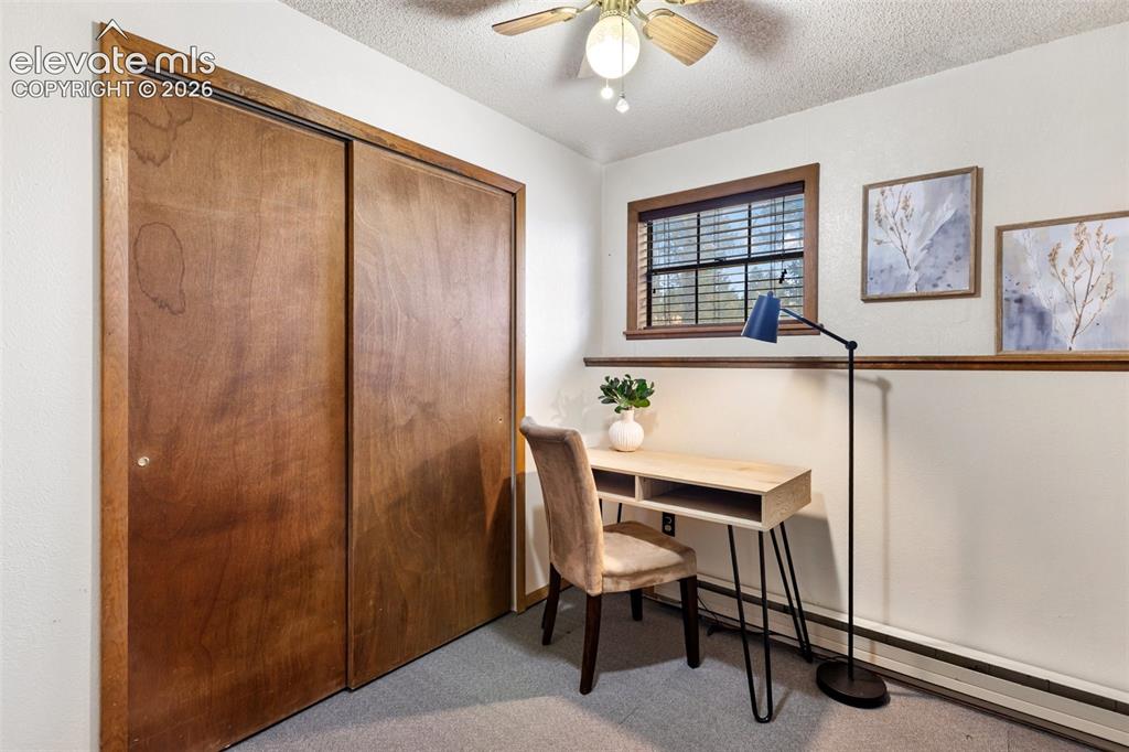 Image 26 of 41: Room featuring wood-finish sliding closet doors, a single window with blind
