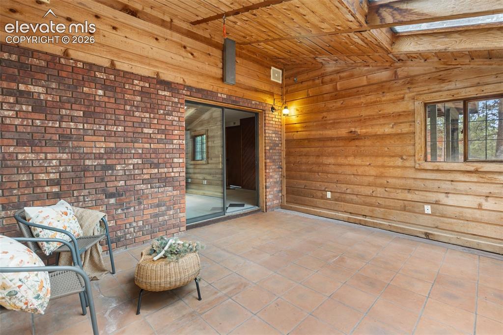 Image 30 of 41: Sunroom featuring wood-paneled walls and ceiling, a skylight, and large for