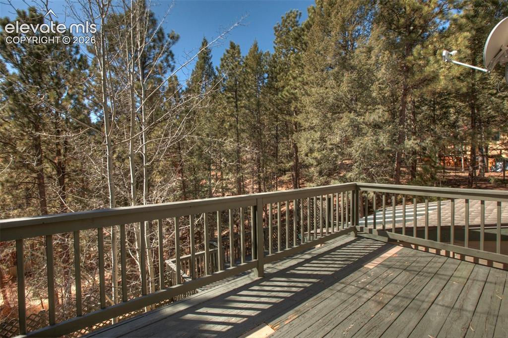 Image 34 of 41: Expansive outdoor deck with wood railing and slatted floorboards