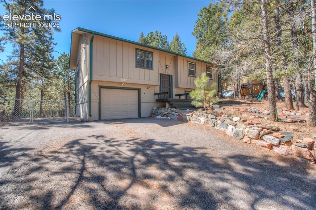 Image 36 of 41: Split-level residence featuring a sinlge-car garage and a paved driveway