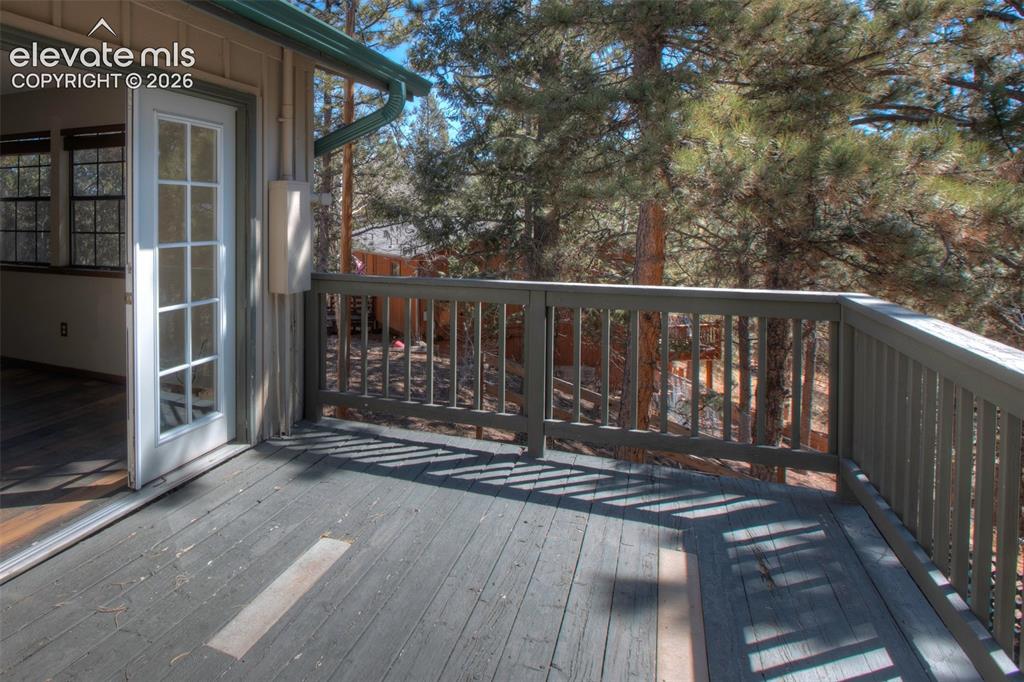 Image 37 of 41: Expansive exterior deck featuring a sturdy wooden railing and a sliding gla
