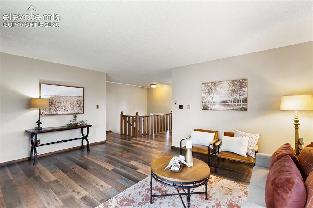 Image 5 of 41: Spacious living area featuring wood-finish flooring, and a neutral color pa