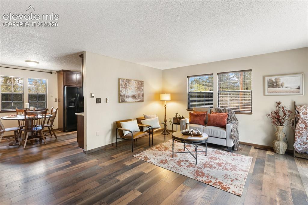Image 6 of 41: Spacious living area featuring wood-finish flooring, neutral wall tones, an