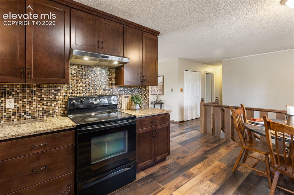 Image 9 of 41: Kitchen featuring wood-finish cabinetry, black electric range with stainles