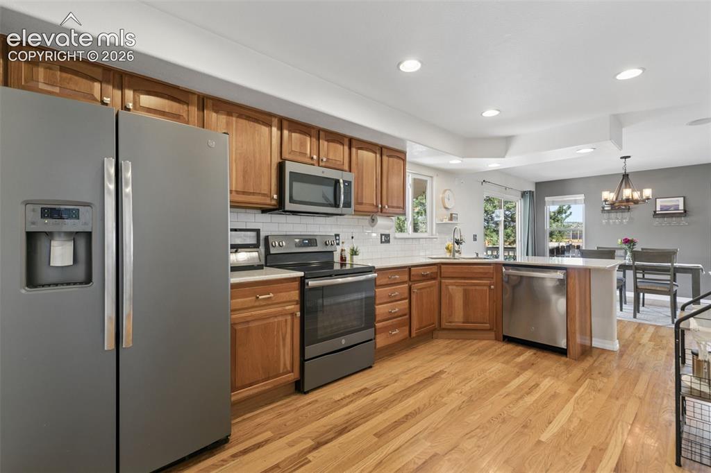 Image 10 of 48: Kitchen featuring wood cabinetry, stainless steel appliances, white subway 
