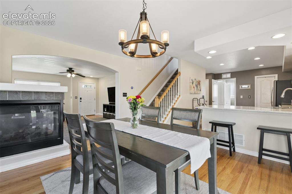 Image 12 of 48: Hardwood-finish flooring, recessed lighting, and a kitchen island with seat