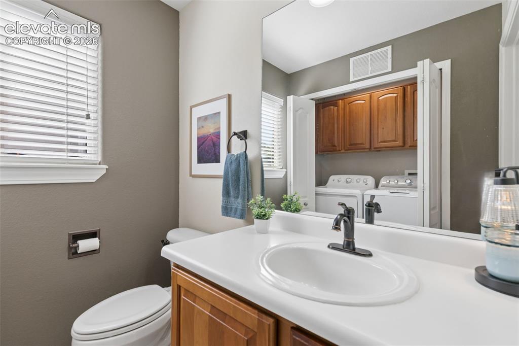 Image 17 of 48: Bathroom featuring a single-sink vanity with wood-finish cabinetry, a white