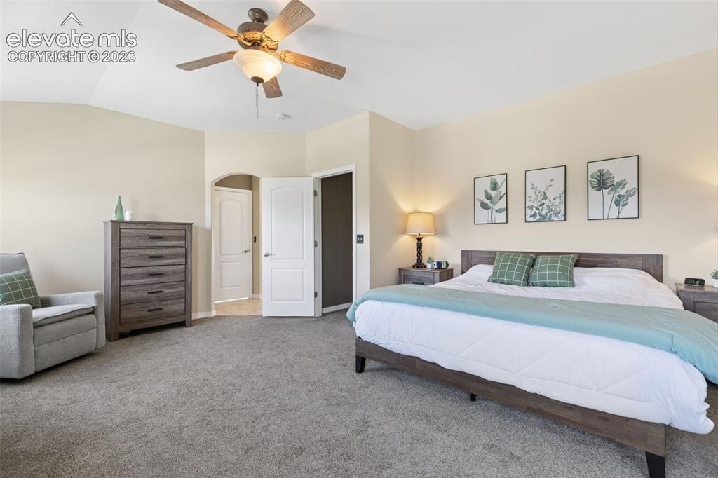 Image 20 of 48: Neutral wall color, ceiling fan with integrated lighting, arched doorway, a
