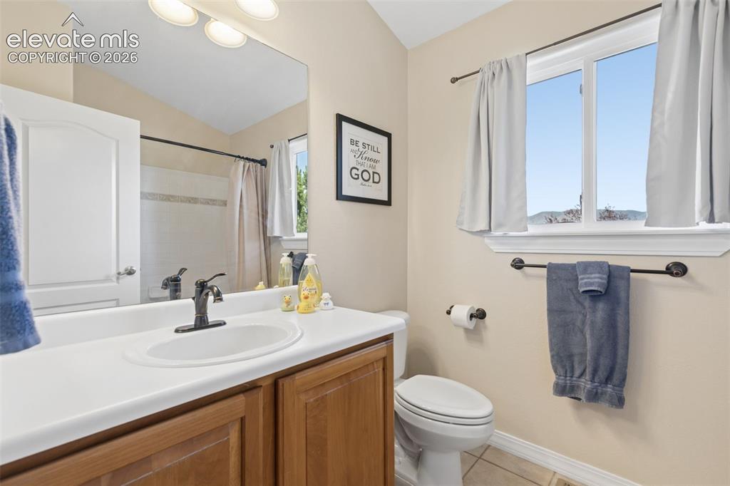 Image 28 of 48: Bathroom featuring a wood-finish vanity with an integrated sink, broad wall