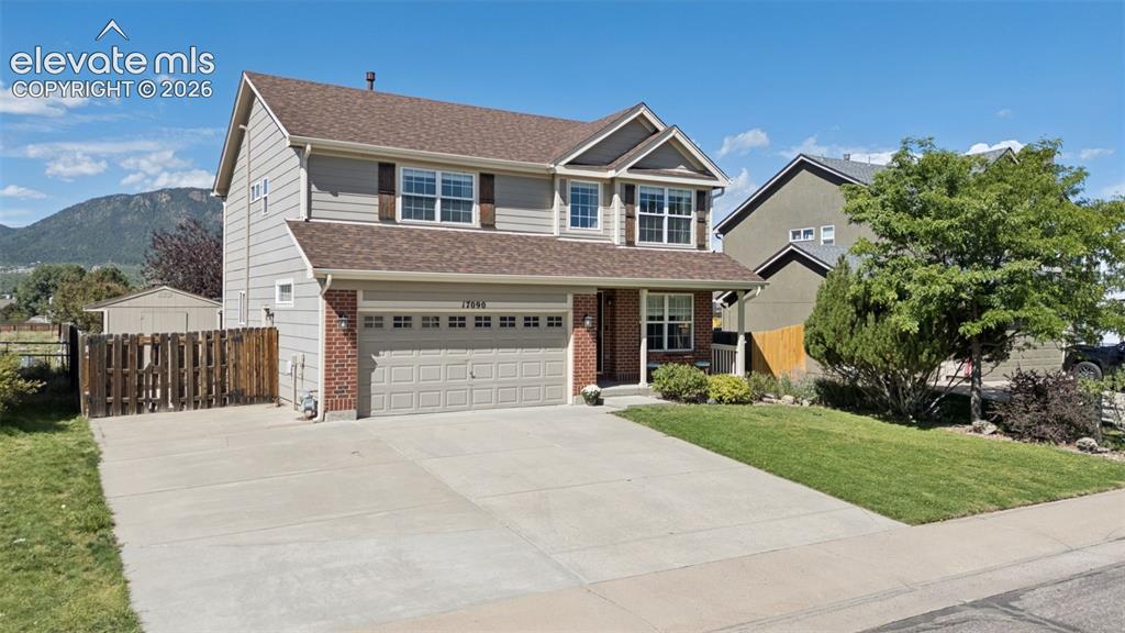 Image 40 of 48: Two-story residence with a two-car garage, brick facade accents, and a conc
