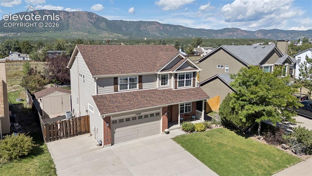 Image 42 of 48: Two-story residence with a two-car garage, brick and siding exterior, and a