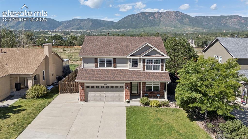 Image 45 of 48: Two-story residence with a two-car garage, brick and siding exterior, and a