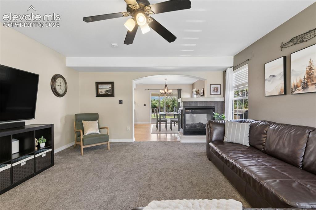Image 8 of 48: Carpeted living area with a ceiling fan light fixture