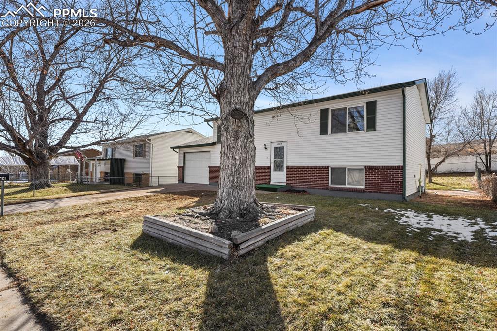 Image 2 of 49: View of front of home with brick siding, driveway, and a garage