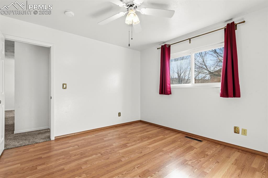 Image 21 of 49: Spare room featuring light wood finished floors and ceiling fan