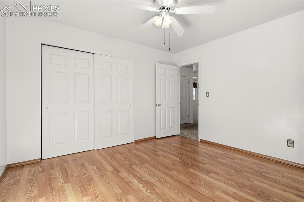 Image 22 of 49: Unfurnished bedroom with a closet, ceiling fan, and light wood finished flo