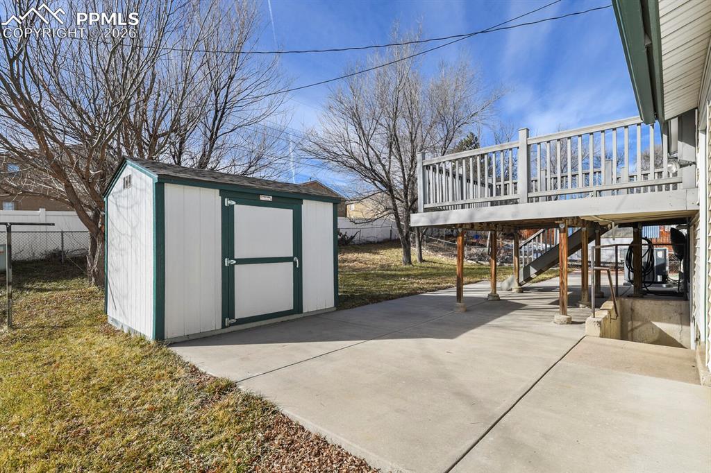Image 38 of 49: View of patio / terrace with stairway, a deck, and a storage shed
