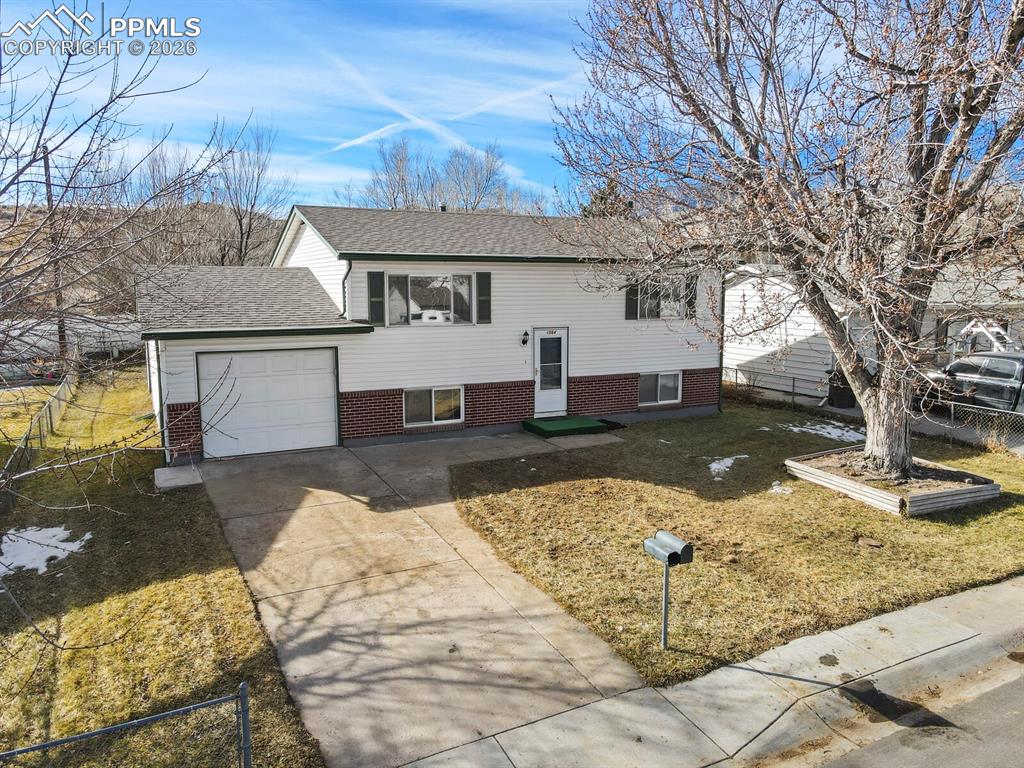 Image 43 of 49: View of front of home featuring brick siding, concrete driveway, roof with 