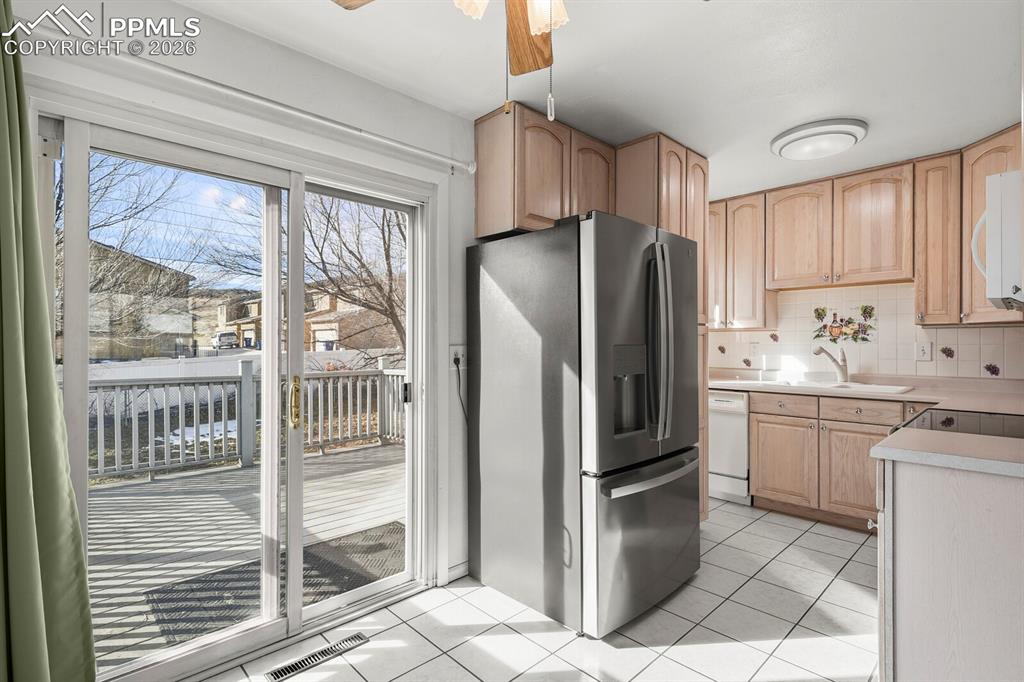 Image 8 of 49: Kitchen with light brown cabinets, white appliances, light countertops, lig