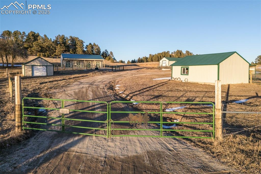 Image 35 of 46: Property entrance gates and horse barn, and loafing sheds. 5 weatherproof,