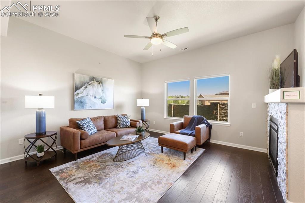 Image 4 of 19: Living room featuring dark wood-type flooring, ceiling fan, baseboards, and