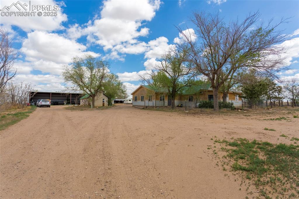 Image 26 of 26: Ranch-style house with a detached carport, driveway, and fence