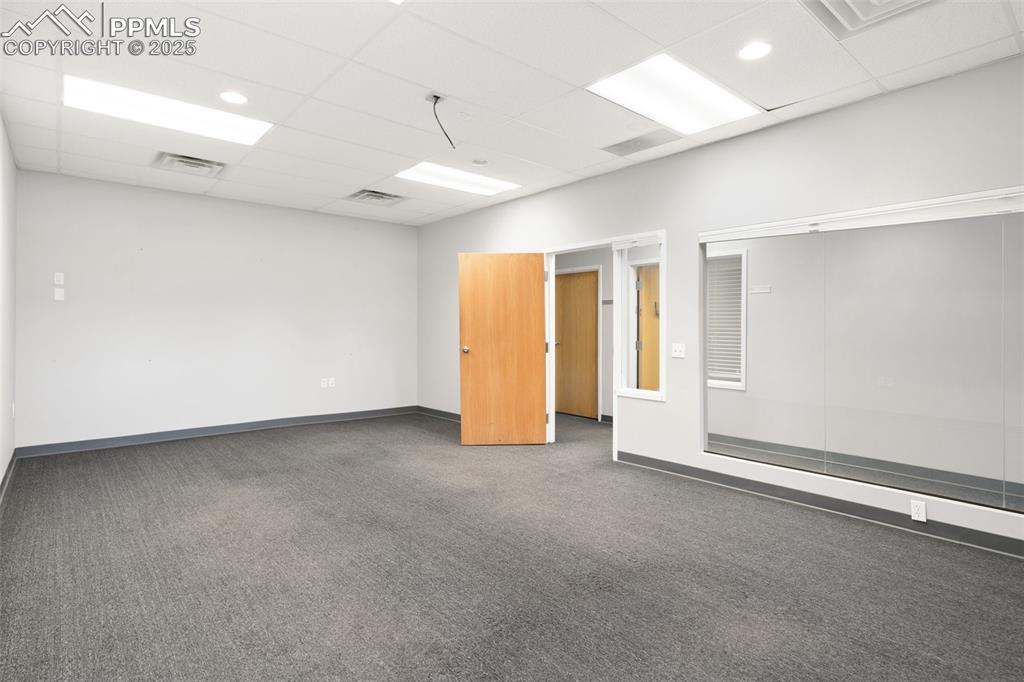 Image 18 of 26: Spare room featuring a paneled ceiling and carpet floors