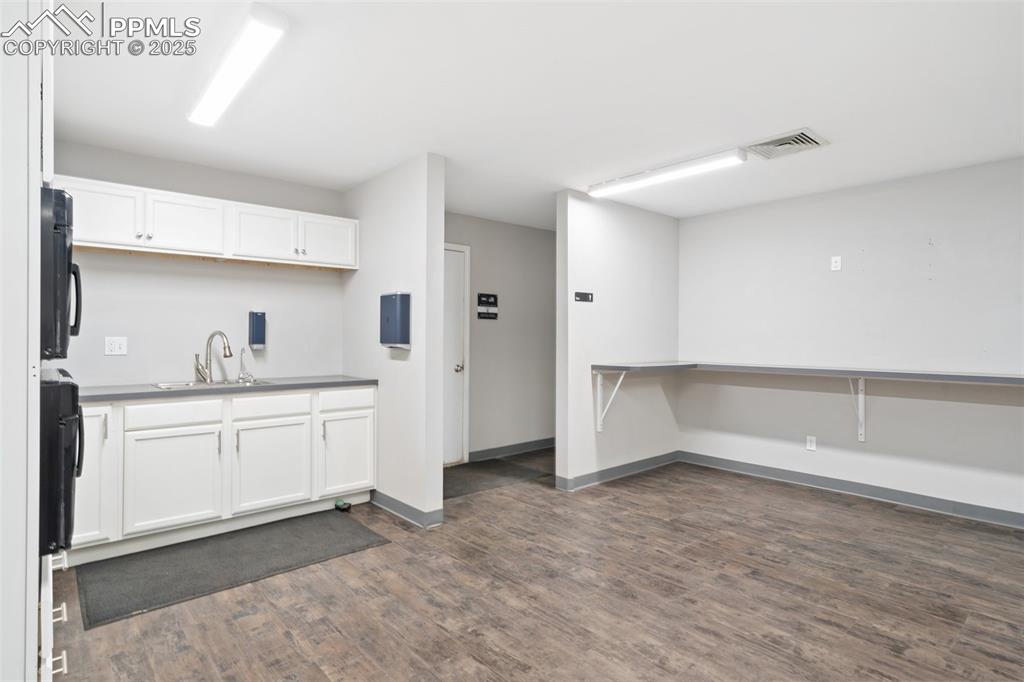 Image 20 of 26: Kitchen featuring white cabinets and dark wood finished floors